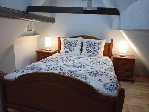 a bedroom with a bed with blue and white sheets and two lamps at Appartement in Kesseldorf