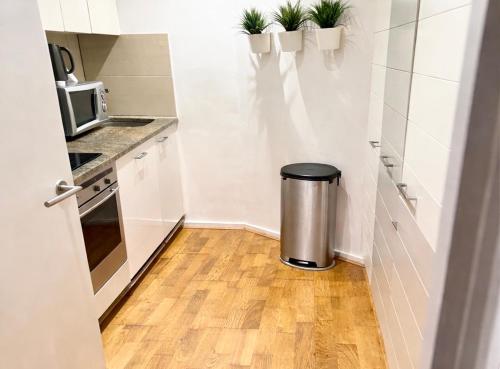 a small white kitchen with a trash can in it at Canary Wharf Riverside gateway in London