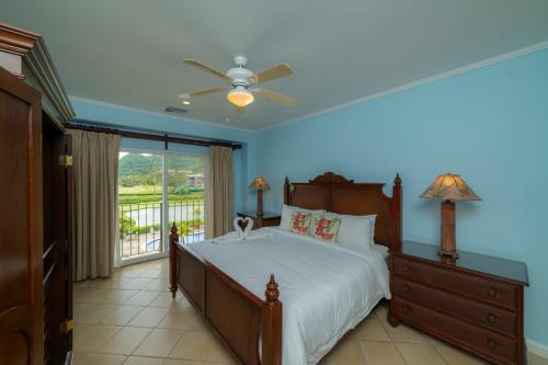 a bedroom with a bed with a ceiling fan and a window at Del Mar 3C 3 bdr Ocean View in Los Suenos in Herradura