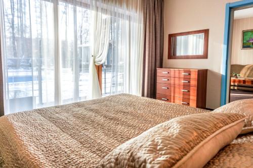 a bedroom with a bed and a large window at Vila Vitalija in Palanga