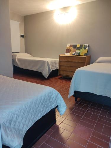 a room with two beds and a dresser and a room with two beds at Apart La Empedrada in Trapiche