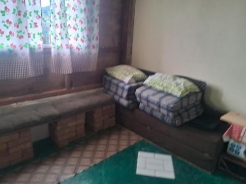 a small room with a couch and a window at Camping caminho das pedras in São Bento do Sapucaí