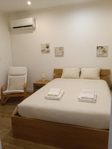 a bedroom with a bed with two towels on it at Casa do Negrão in Ponta Delgada