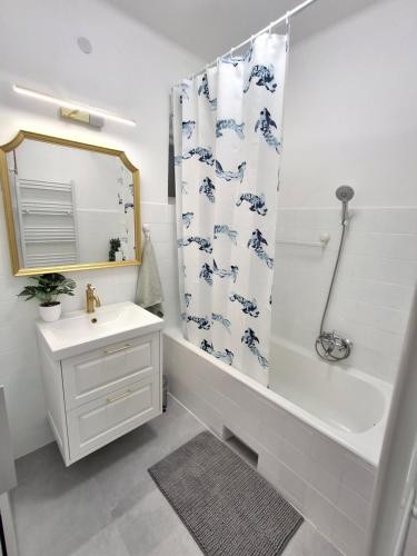 a bathroom with a sink and a shower curtain at Villa Hortensia in Aszófő
