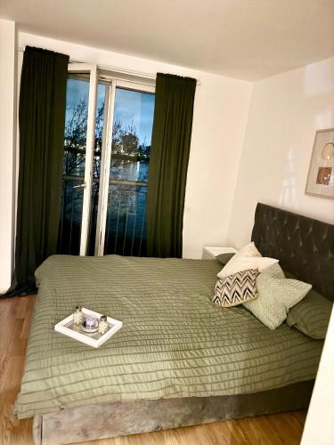 a bedroom with a bed and a large window at Canary Wharf Riverside gateway in London