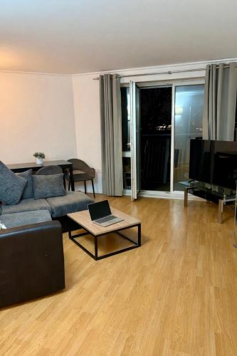 a living room with a couch and a table and a tv at Canary Wharf Riverside gateway in London