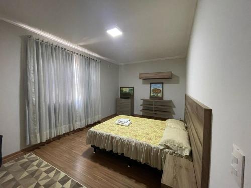 a bedroom with a bed and a large window at Sobrado Premium - Zona Sul in Maringá