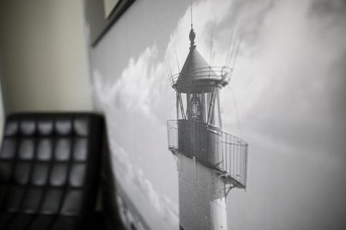 a black and white photo of a lighthouse on a wall at Hostal Cabo Mayor in Santander