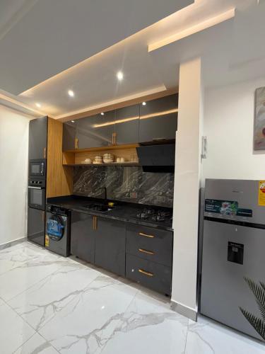 una cucina con mobili grigi e una stufa di Ritz Apartment a Accra
