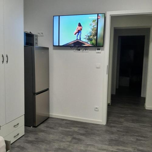 a flat screen tv on a wall in a room at Five Rooms in Sinsheim