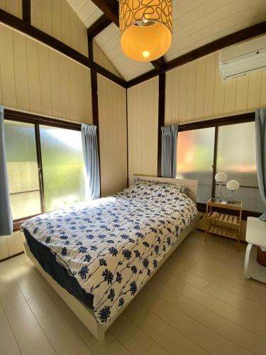 a bedroom with a bed in a room with windows at Aqua Beach House Sotoura - 1min walk to Sotoura Beach! in Shimoda