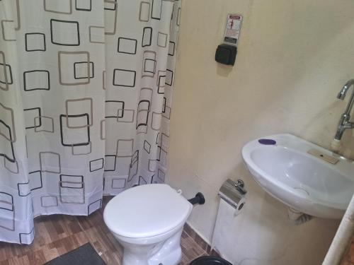a bathroom with a toilet and a sink at Camping caminho das pedras in São Bento do Sapucaí