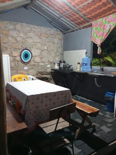 a room with a table and a kitchen with a sink at Chalés do quintal da chapada in Palmeiras