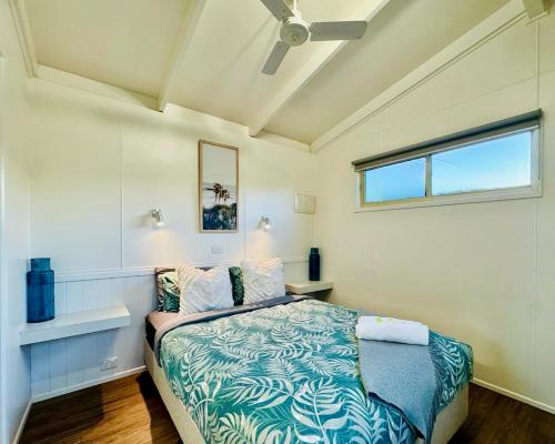 a bedroom with a bed and a window at Kanasta Caravan Park in Rye