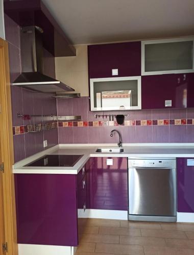 a kitchen with purple cabinets and a sink at Enjoy Sevilla in La Rinconada