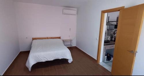 a small bedroom with a bed in a room at Enjoy Sevilla in La Rinconada