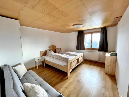 a bedroom with a bed and a couch at Chalet Talblick in Riederalp