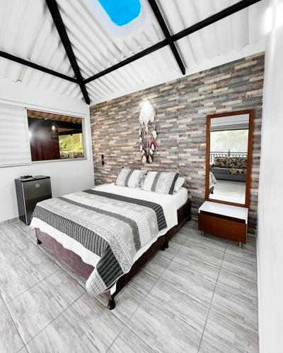 a bedroom with a bed and a brick wall at Hotel cabañas sol paz DF in La Vega