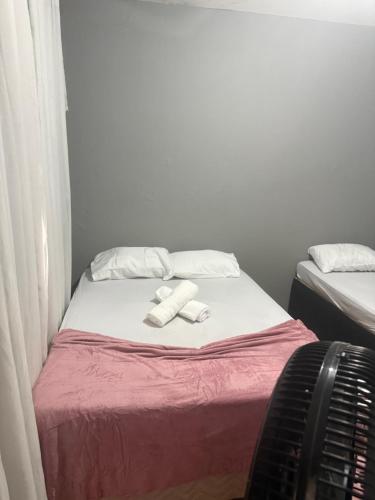a small bed with two towels on top of it at Pousada Bem estar in Divinópolis