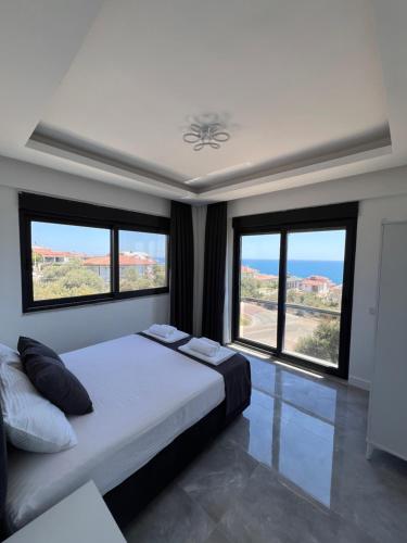 a bedroom with a large bed with large windows at Villa Bella Demre in Kum