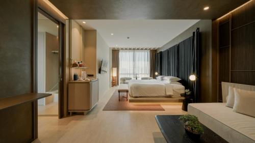 a bedroom with a bed and a living room at Grand Vista Hotel Chiangrai in Chiang Rai