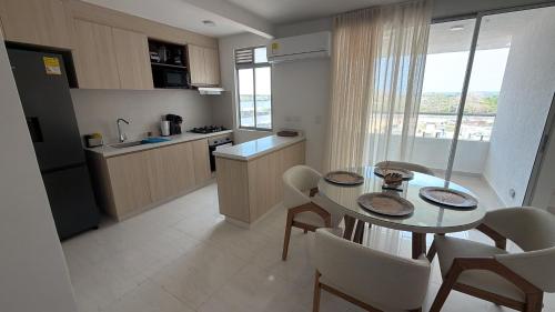 a kitchen with a table and chairs and a kitchen with a window at Cartagena Serena Del Mar INAWA in Cartagena de Indias