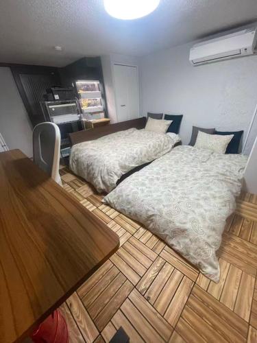 a bedroom with a large bed and a table at Aila apartment in Tokyo