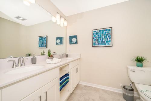 a white bathroom with a sink and a toilet at Beautiful Apartments 5 Minutes away from Disney! in Kissimmee
