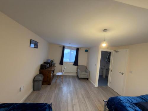 a living room with a bed and a desk in a room at Town Centre Studio with Ensuite in Aylesbury