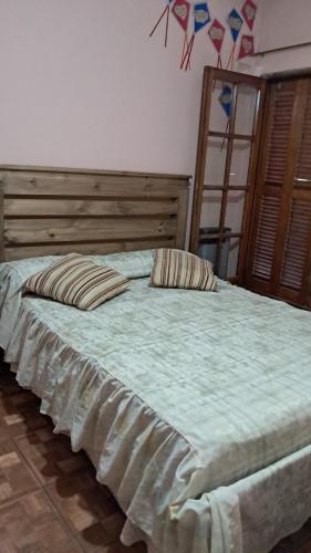 a large bed with two pillows on top of it at Departamento de los pájaros in Córdoba