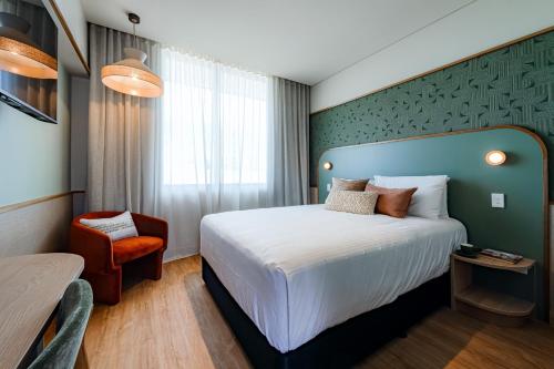 a hotel room with a bed and a chair at The Queens Gladstone in Gladstone