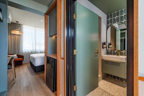 a room with a bathroom with a sink and a mirror at The Queens Hotel Gladstone in Gladstone