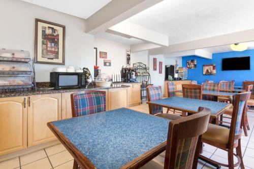 une cuisine et une salle à manger avec des tables et des chaises dans l'établissement Microtel Inn & Suites by Wyndham London, à London