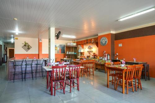 a restaurant with tables and chairs and a bar at Do Parque Pousada in Penha
