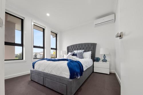a bedroom with a bed and two windows at Gregory Hills Haven Luxe in Gledswood Hills