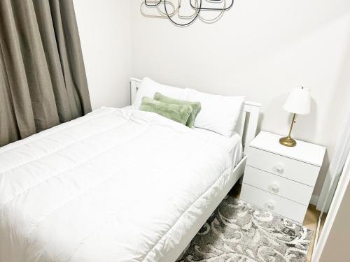 a bedroom with a white bed and a night stand at DeHaven in Edmonton