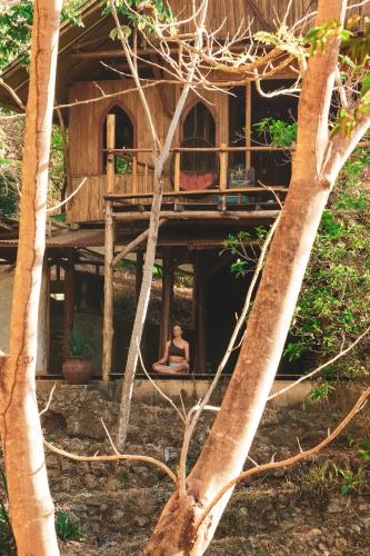 a woman sitting on the porch of a tree house at Alya Jungle Casitas in San Juanillo