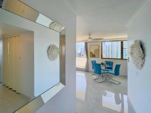 a living room with a mirror and blue chairs at The Enderley Escape in Gold Coast