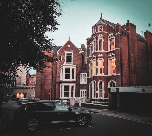 a car parked in front of a large brick building at Wellington Circus in Nottingham