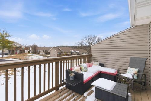 a balcony with a bench and a chair on a porch at TaneyCoMo Topia Quaint Studio in Branson