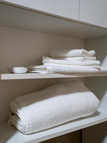 a closet with white towels on a shelf at Komfortresidenz Natur in Weiz