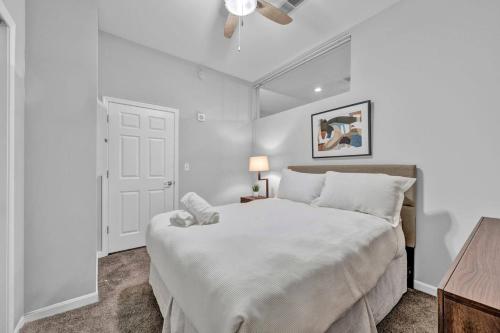 a white bedroom with a large bed and a table at Central Downtown Condo | Parking & Pool Table in Cleveland