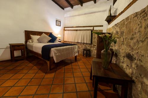 a bedroom with a bed and a table in a room at Casa Huitsiki in Cuetzalán del Progreso