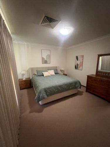 a bedroom with a green bed and a window at 367 The Avenue in Harvey