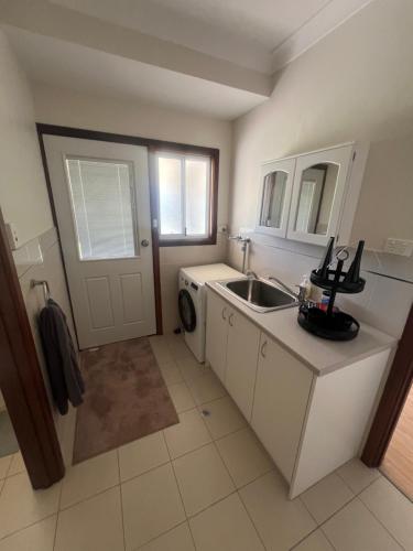 a kitchen with a sink and a washing machine at 367 The Avenue in Harvey