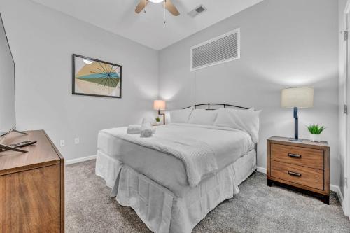 a white bedroom with a bed and a night stand at Theater District Gem • Downtown Hideaway in Cleveland