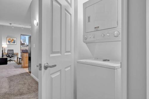 a kitchen with a washer and dryer next to a door at Theater District Gem • Downtown Hideaway in Cleveland