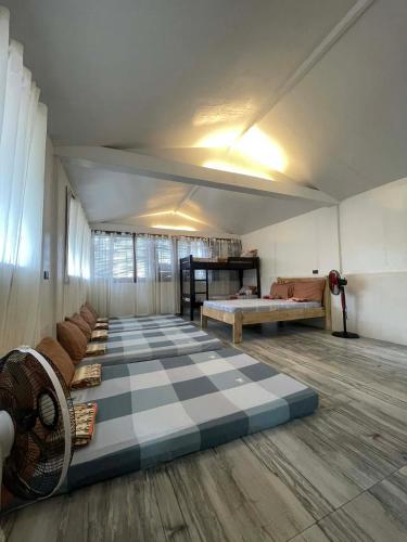 a large room with a checkered floor with a couch and a bed at Gratum Beach 1 & 2 Resorts Glamping in Dapitan