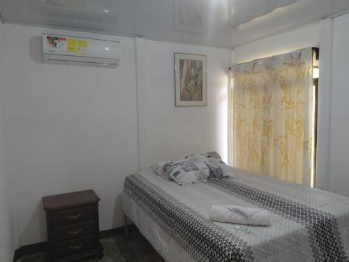 a white bedroom with a bed and a window at Inmoexito Eco Tours in Upala
