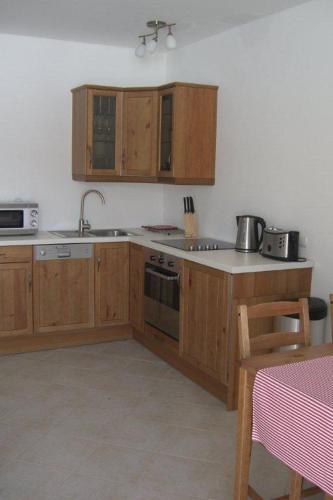 a kitchen with wooden cabinets and a stove top oven at Villa Dorota in Zakopane